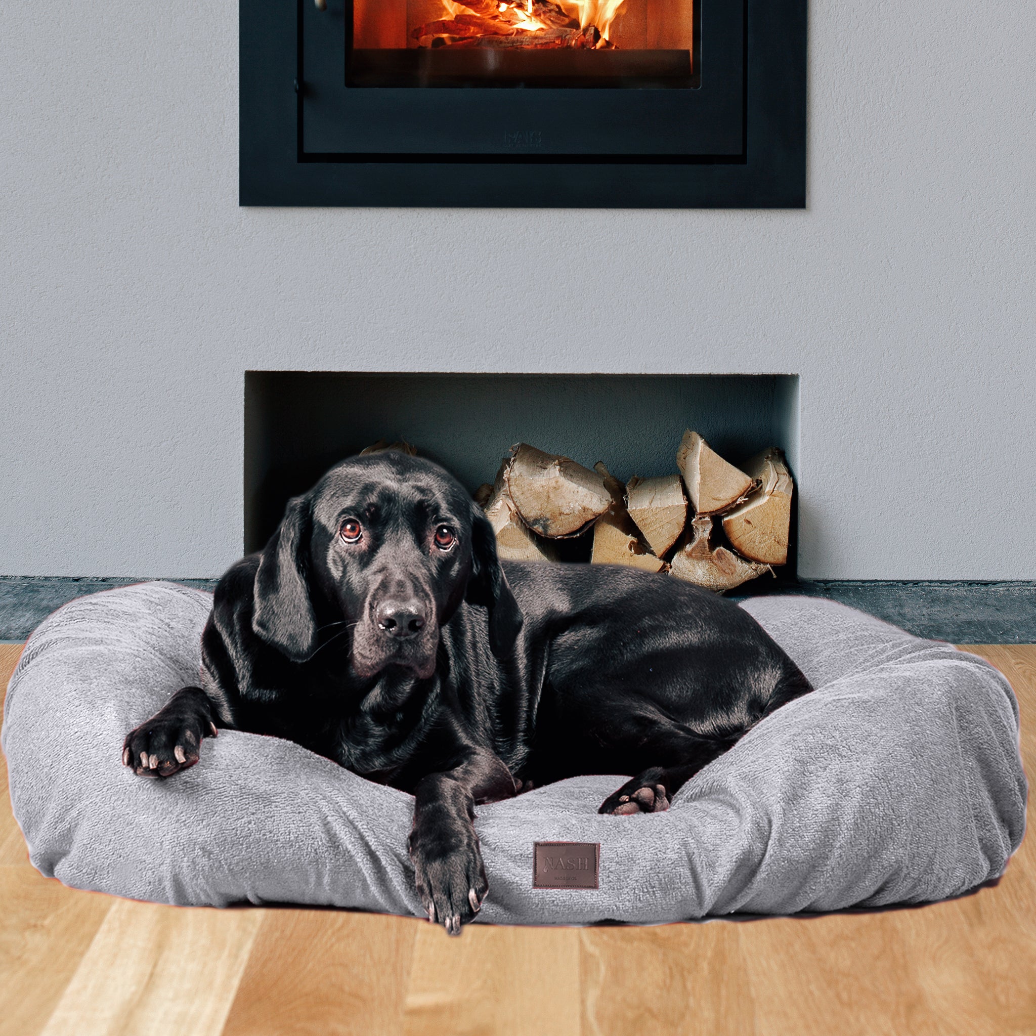Labrador dog resting on its dog bed at home, which is protected using the NASH bamboo dog bed cover in grey. 